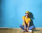 Woman in Yellow Shirt  Sitting on Brown Wooden Floor