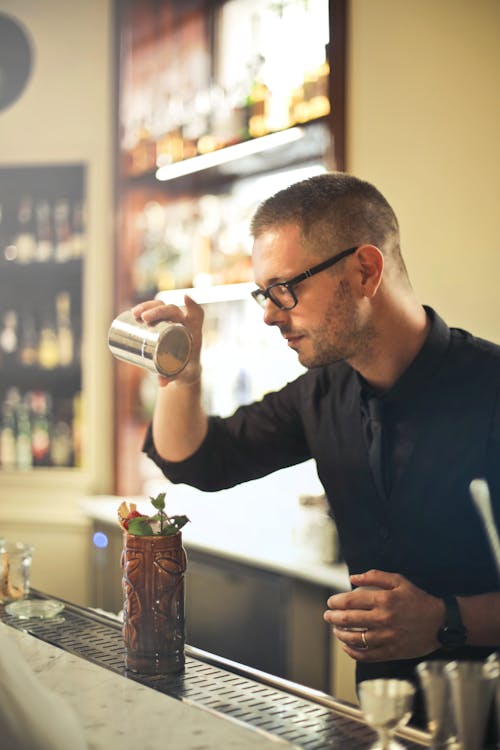 L'uomo Versando Bevande Alcoliche Sul Bicchiere Da Cocktail