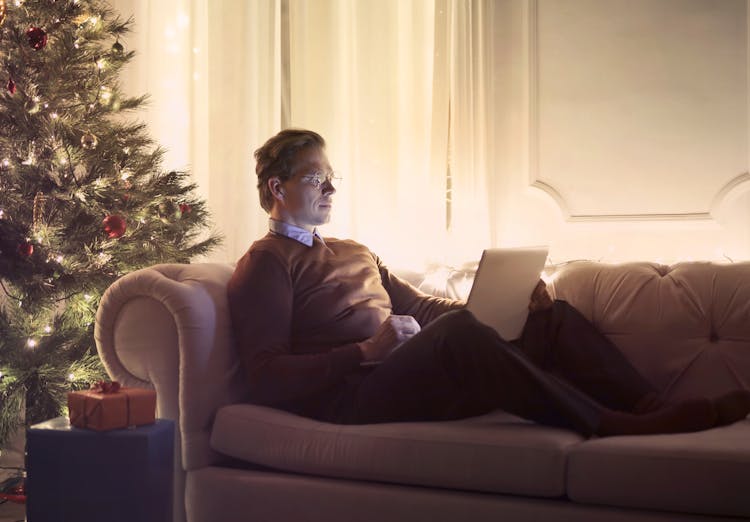 Man Using Laptop While Sitting On Sofa