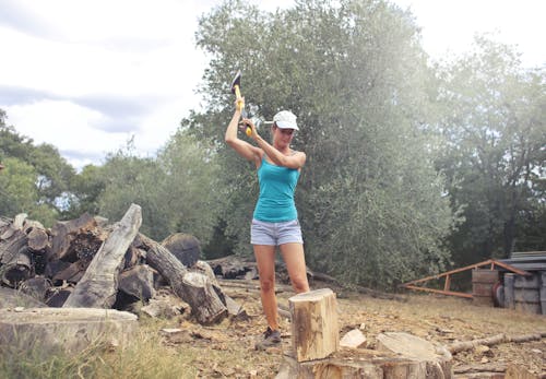 Young woman chopping wood in countryside