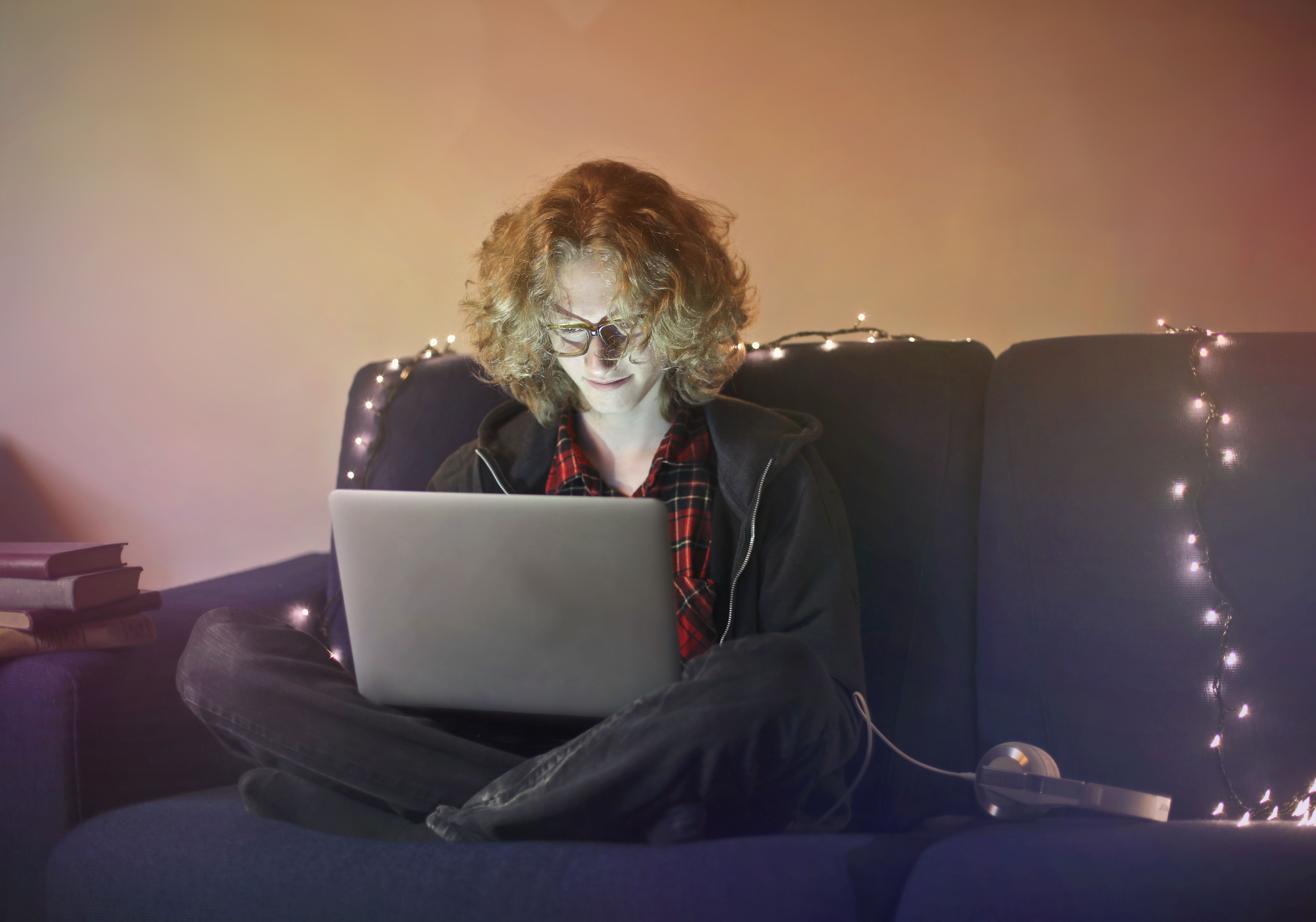 Pessoa trabalhando em laptop com ícones de redes sociais flutuando ao redor, simbolizando o sucesso nas mídias sociais.