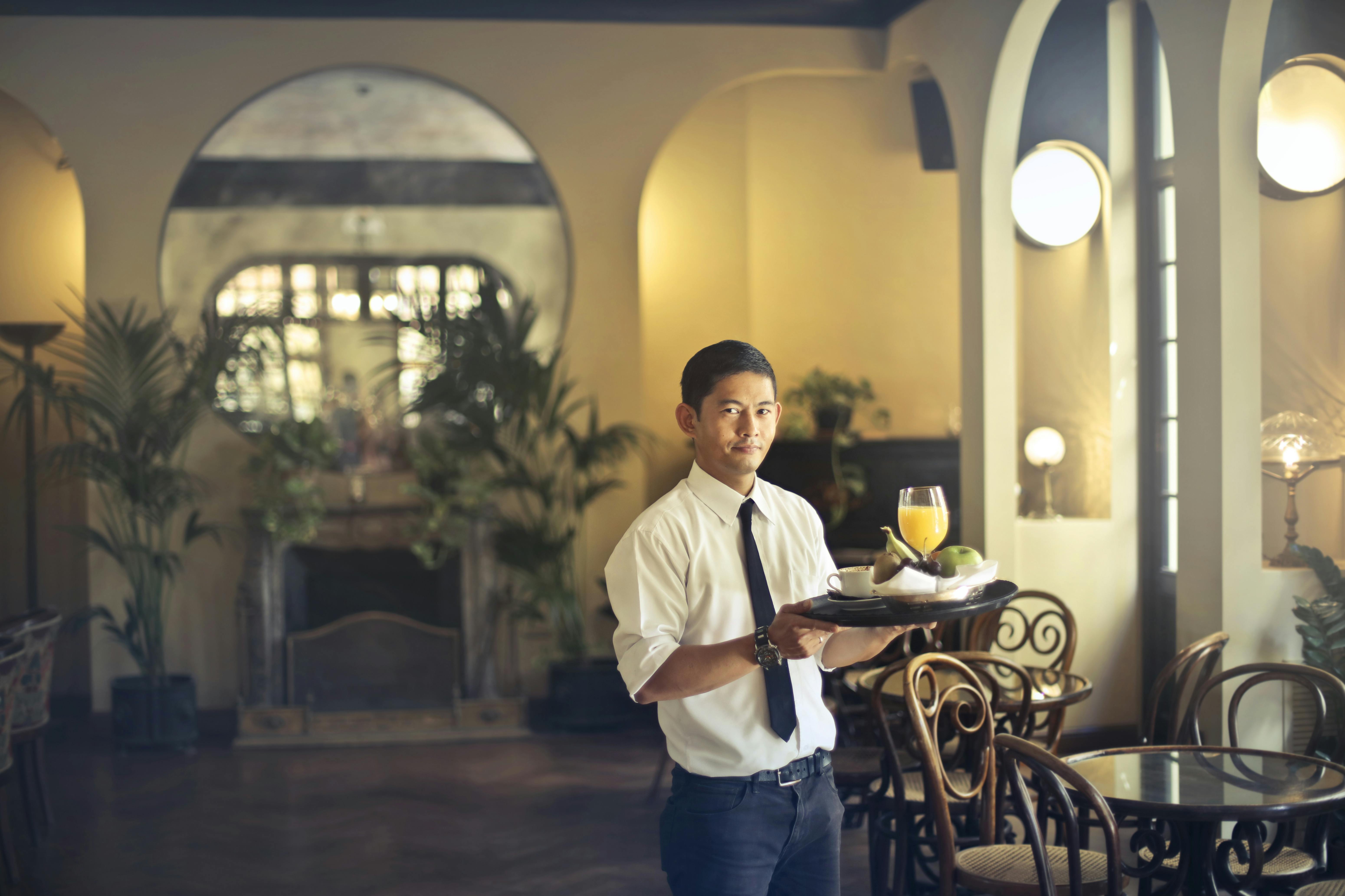 waiter with tray working in stylish restaurant