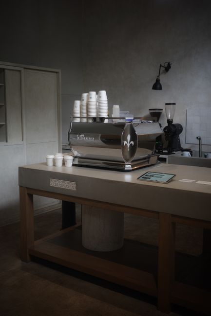 Stylish coffee shop interior featuring a sleek espresso machine and stacked cups on a counter.