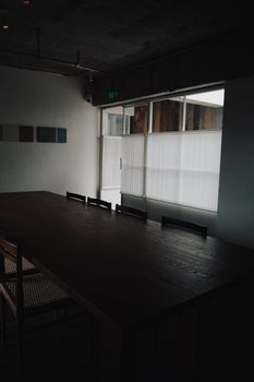 Empty dark conference room with sleek furniture and minimalistic decor.