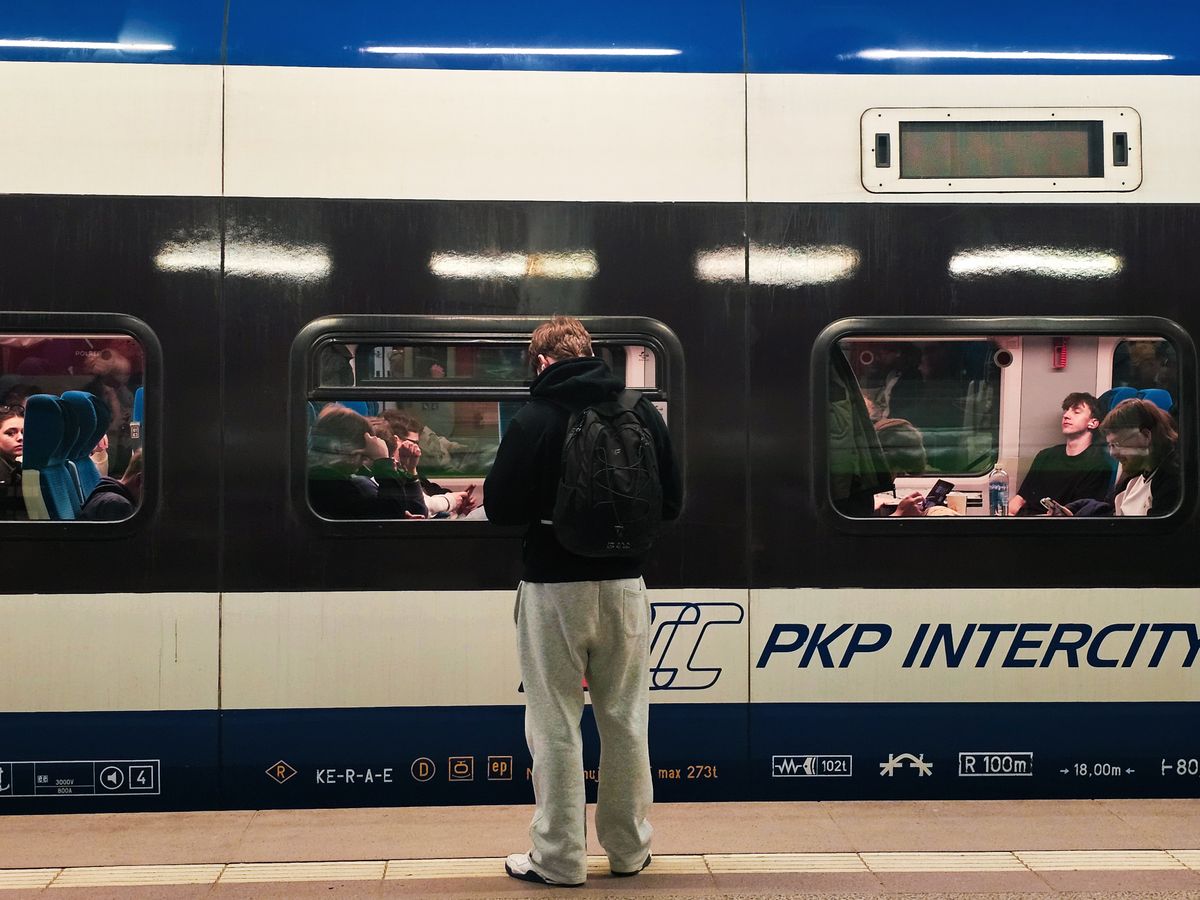 Vagon de tren interurban oprit la peron într-o gară din Wrocław, cu pasageri la ferestre