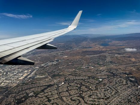 Scenic aerial view of a sprawling urban landscape captured from an airplane window during flight.
