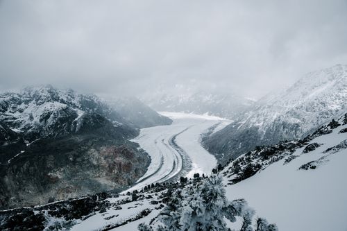 Free A panoramic aerial shot of the snow-covered mountains in Cevio, Switzerland, showcasing a dramatic winter landscape. Stock Photo