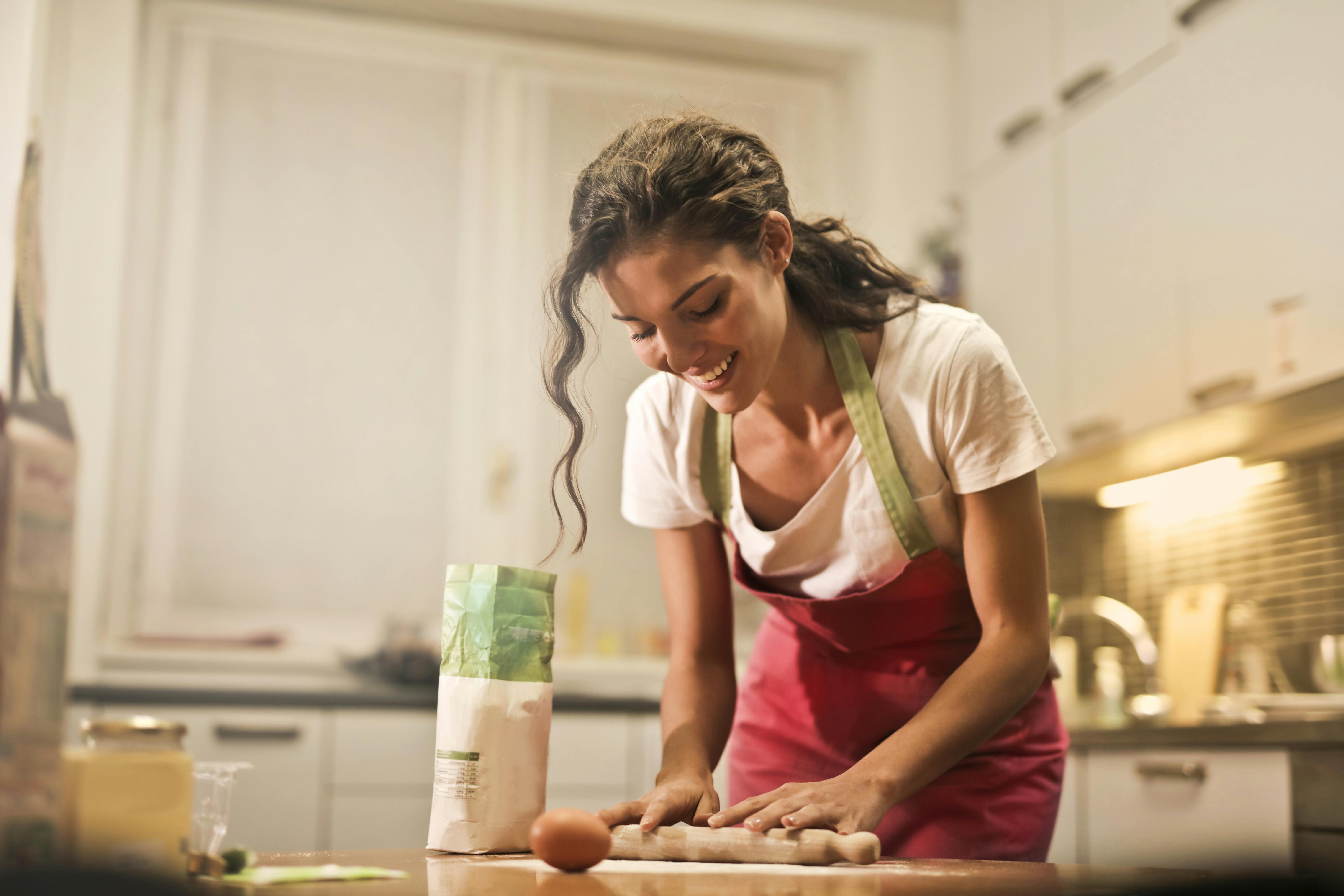 Ama de casa con utensilios de cocina. mujer feliz cocinando comida