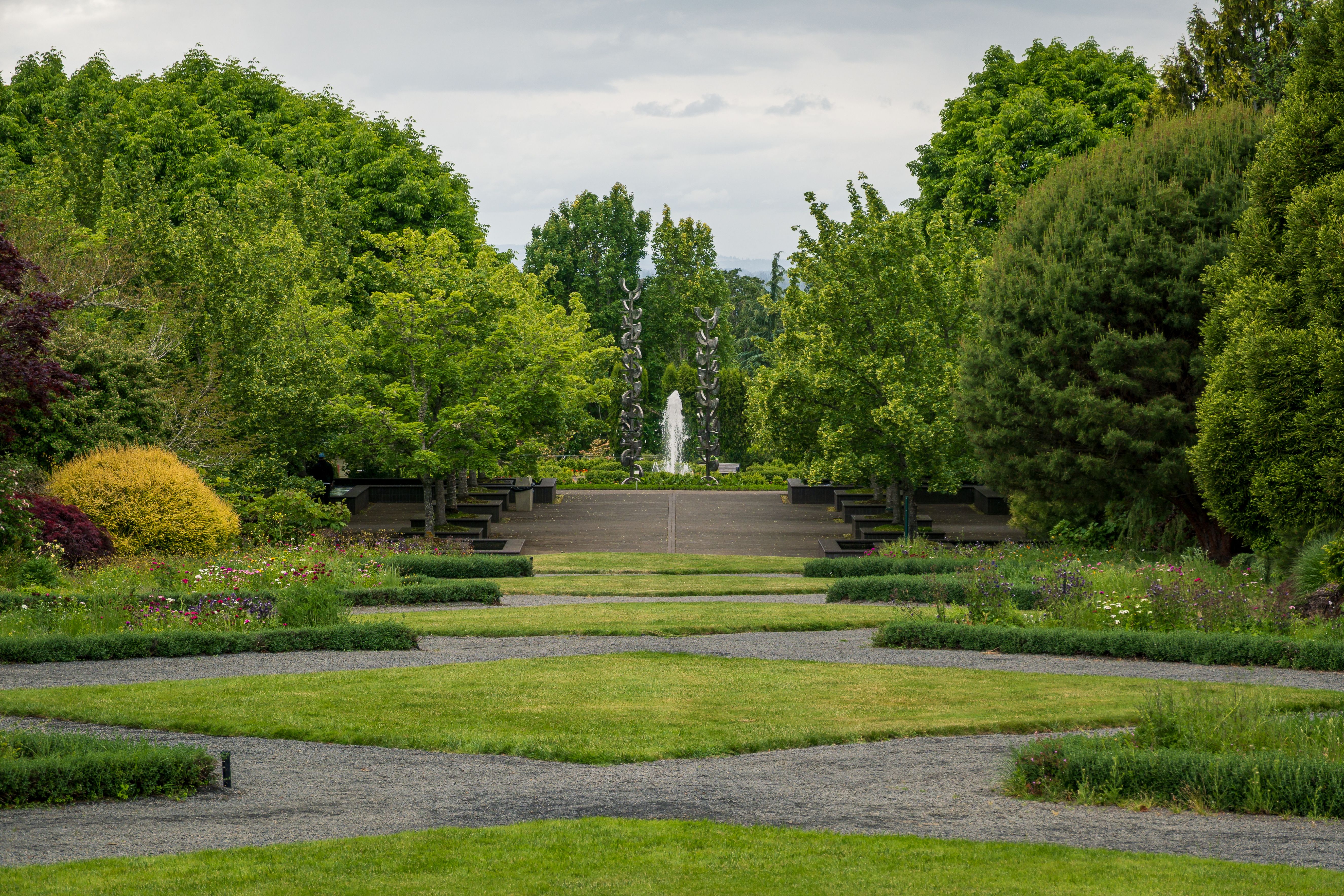 Sculptural artworks lining a leafy garden pathway