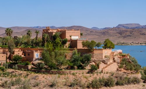 Free Stunning traditional Moroccan architecture overlooking Ouarzazate Lake with mountainous backdrop. Stock Photo