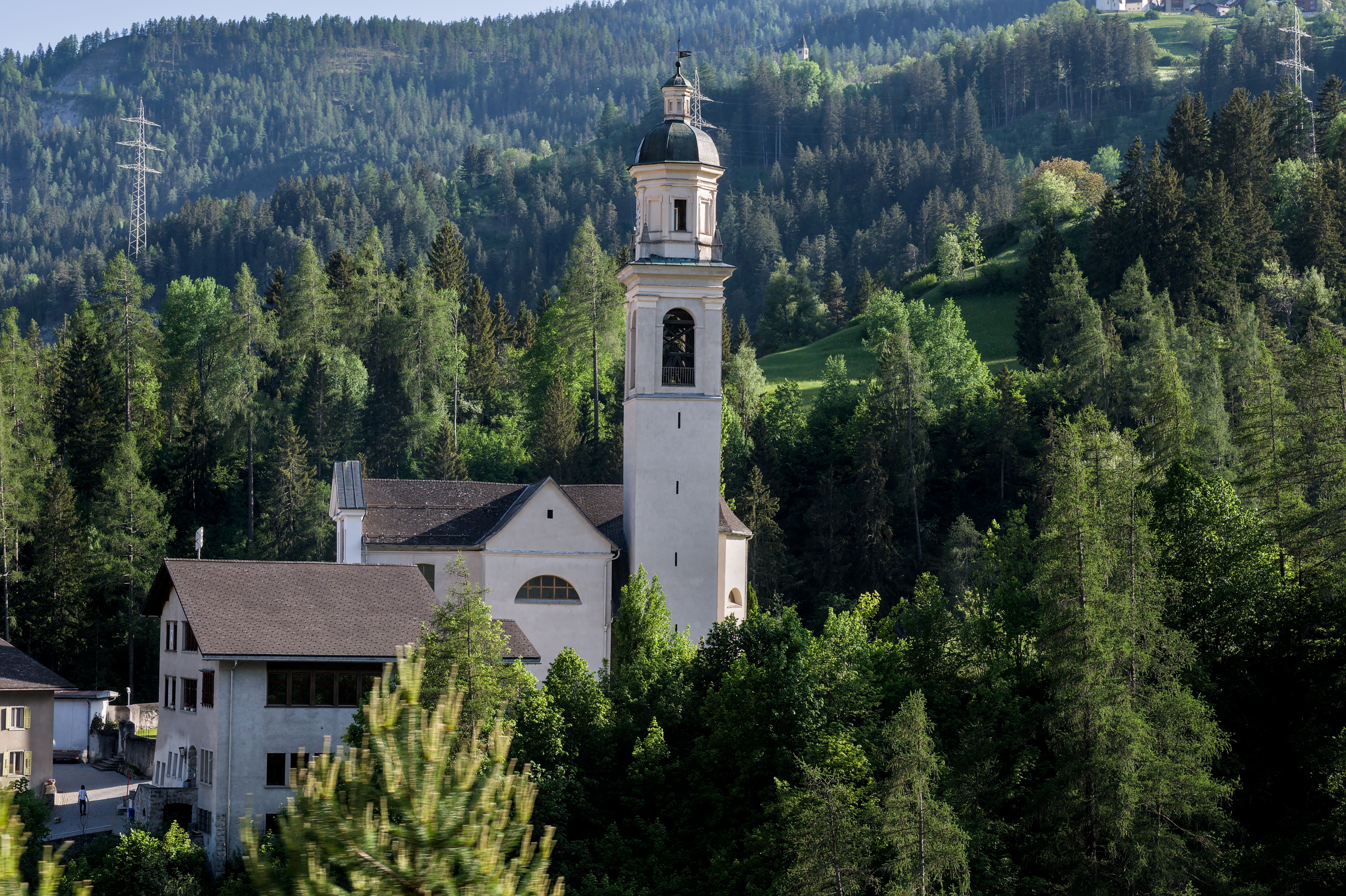 Beautiful church nestled in lush Swiss mountains, highlighting nature's serene beauty.