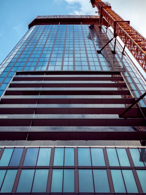 Free A high-rise building with a crane in Wrocław, showcasing modern architecture and urban development. Stock Photo