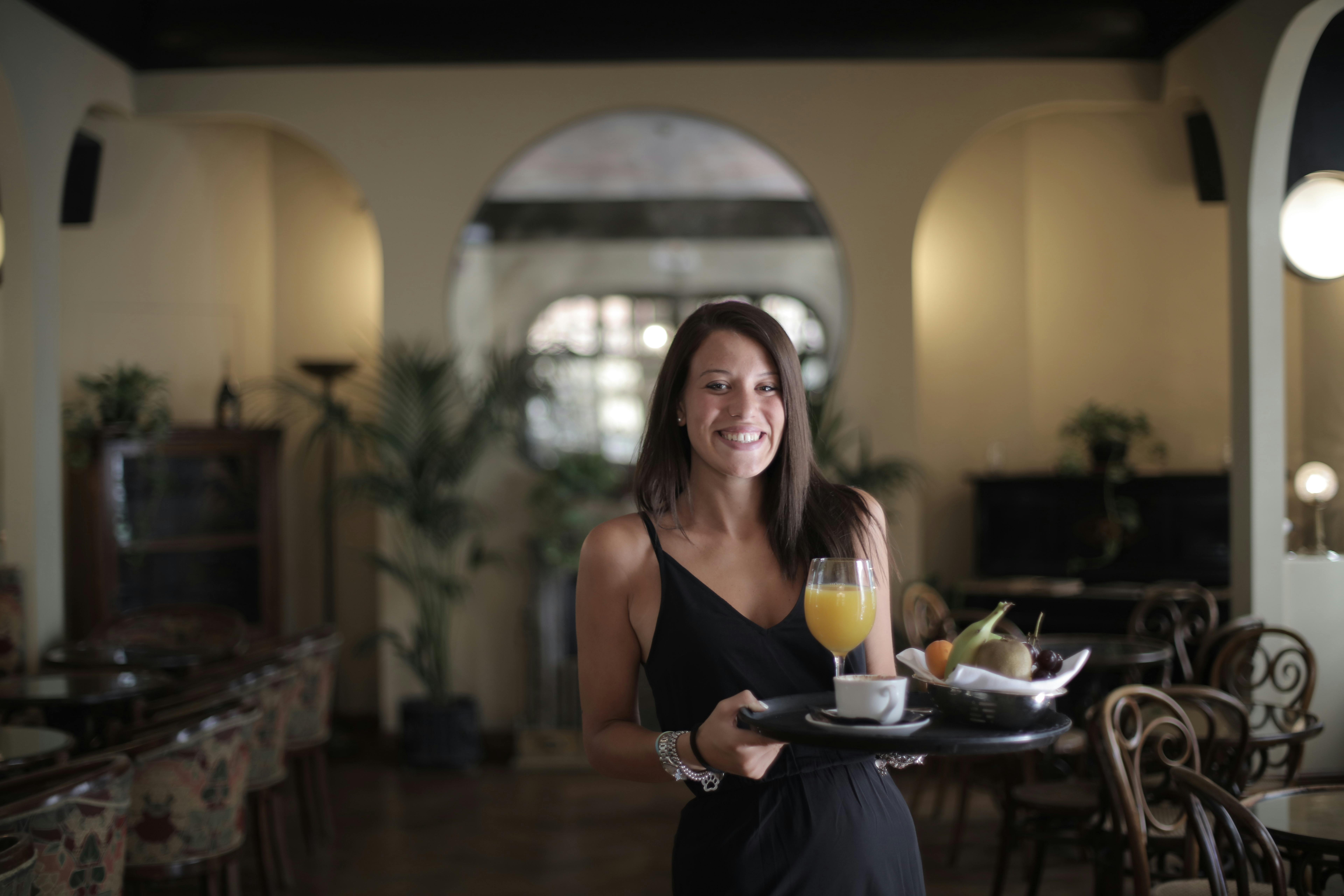 Free Woman in Black Dress Holding Black Food Tray Stock Photo
