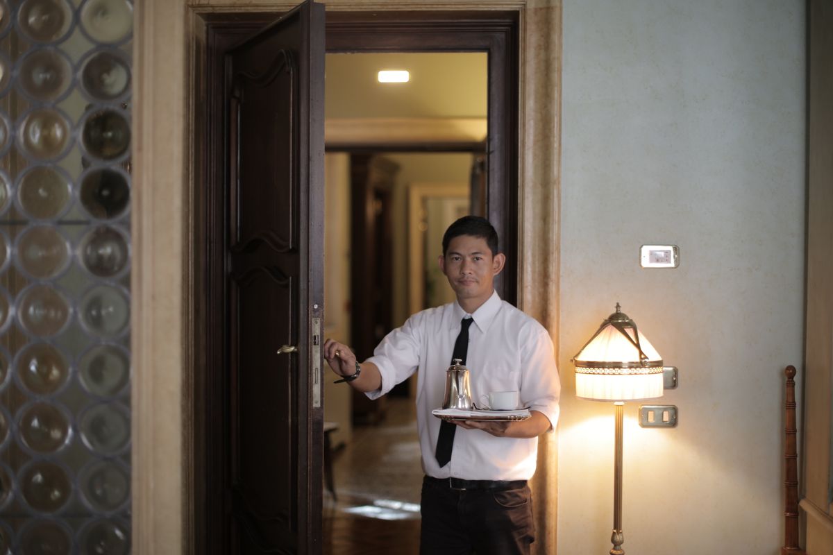Hotel staff member attending to guests, representing POS and shift scheduling workflows in hospitality ERP software