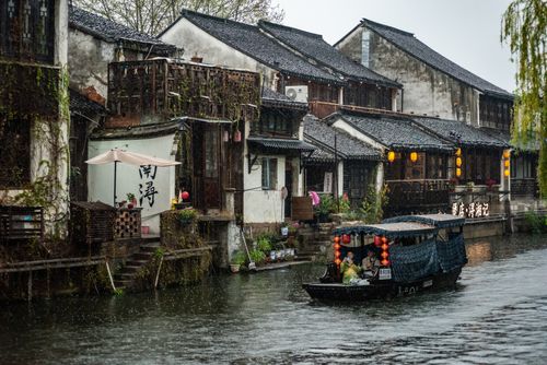 Free Beautiful canal with a boat and traditional Chinese houses in a serene setting. Stock Photo