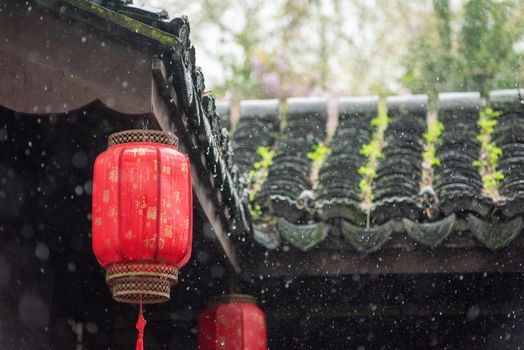 Red Chinese lantern hanging in a traditional courtyard during rain, capturing cultural aesthetics and tranquility.