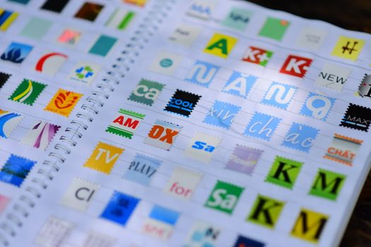 A vibrant mix of colorful stamps displayed in a spiral notebook, showcasing diverse design elements. - Fotografer Sidoarjo