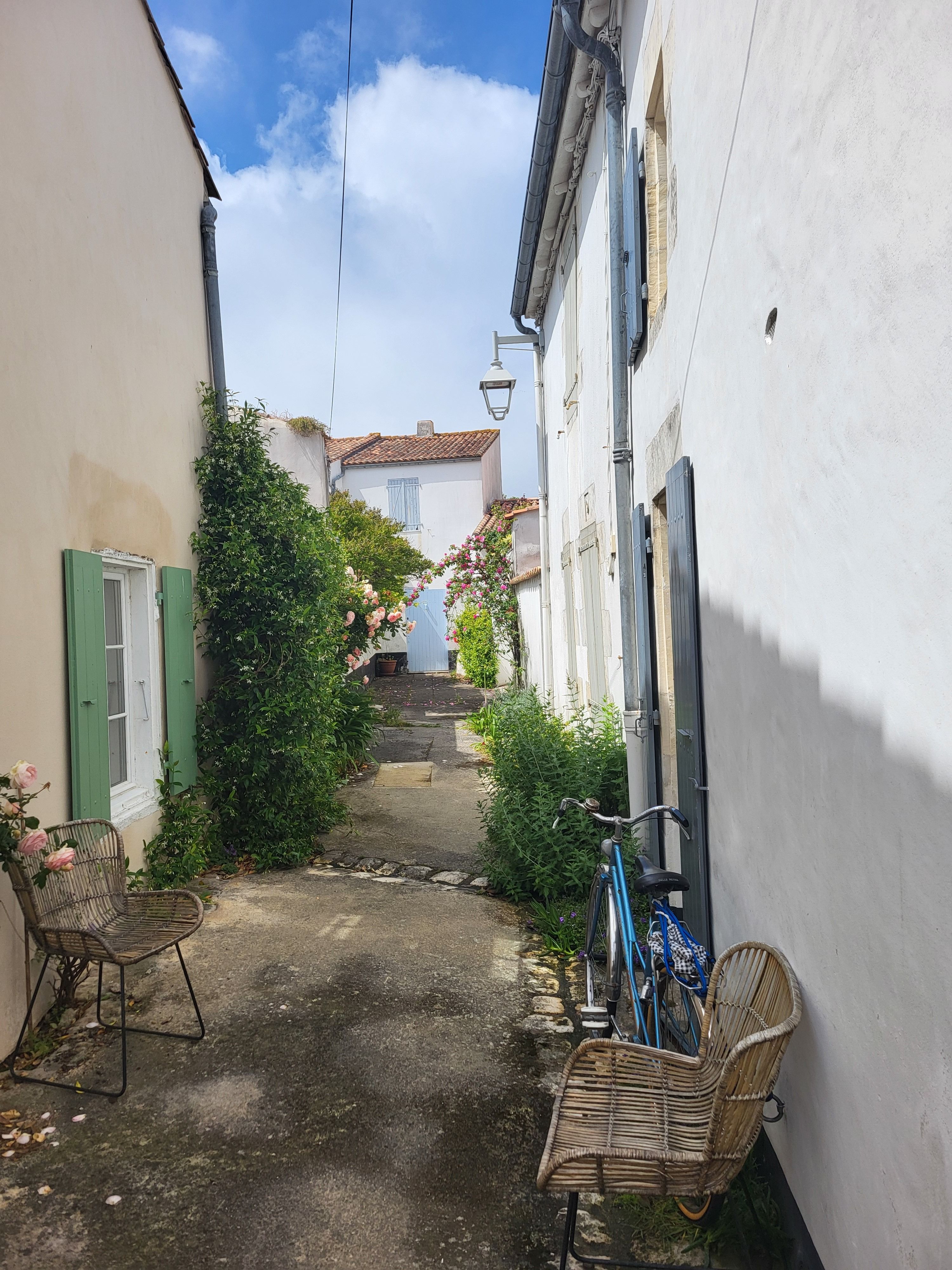 Vélo garé dans une ruelle fleurie d'un village pittoresque français