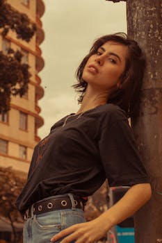 圣保罗街头，一位身着休闲装的时尚年轻女子在灯柱旁摆着姿势