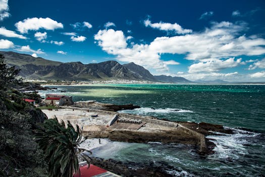 Picturesque view of South African coastal town with mountains and ocean.