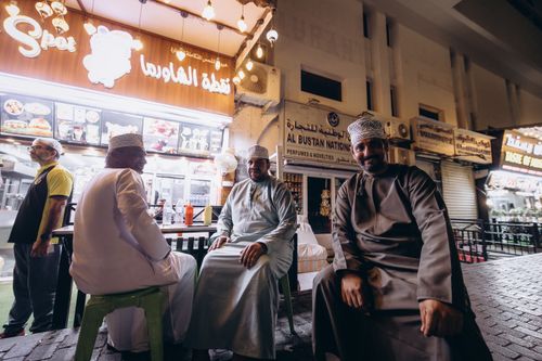 Free A candid street capture of locals dining at a food kiosk in Mutrah, Muscat at night. Stock Photo