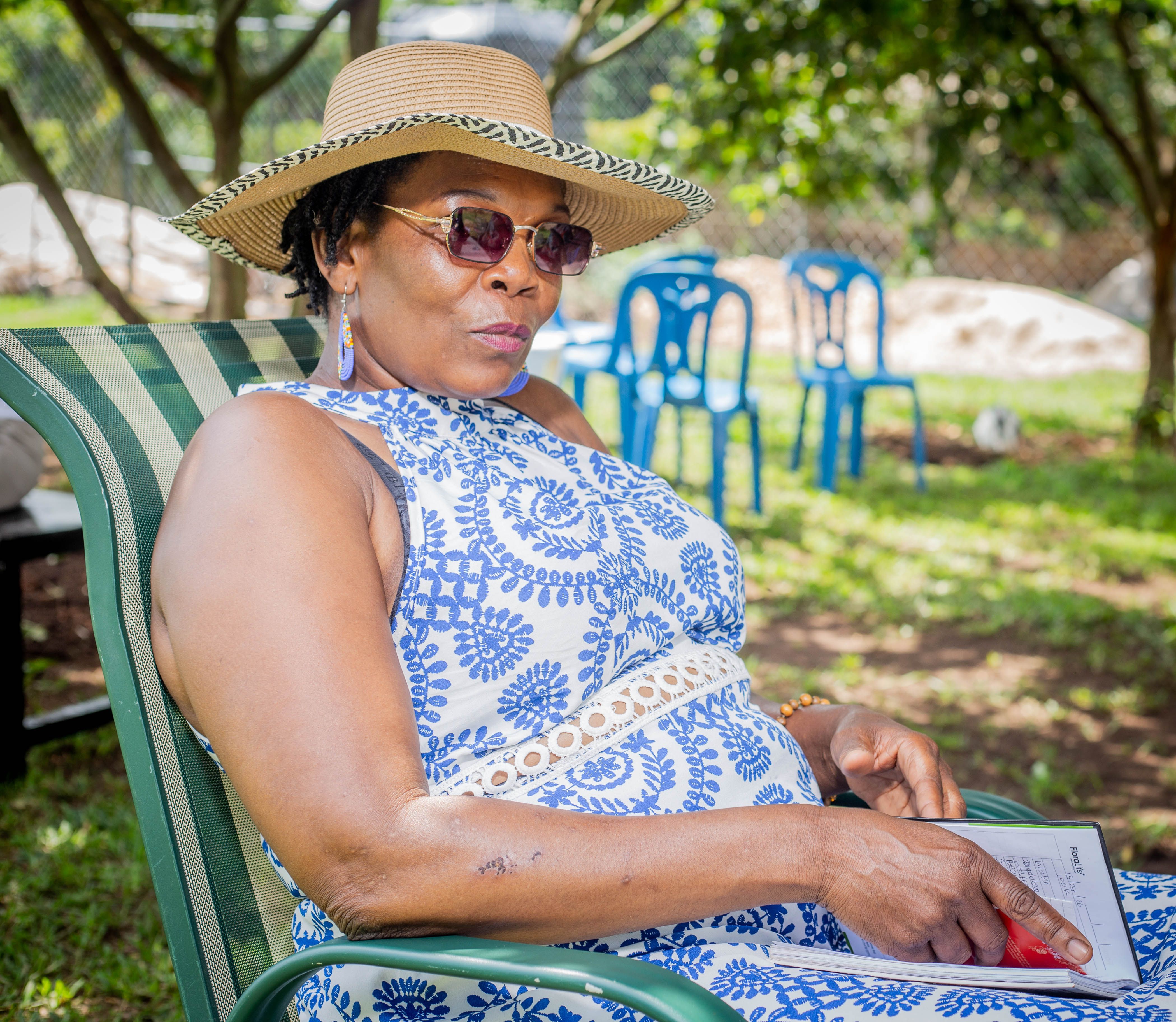 A woman in a floral dress relaxing on a sunny day, embodying leisure and style.