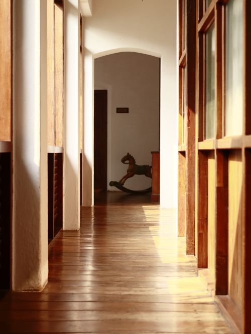 Free A bright wooden hallway leading to a room with a vintage rocking horse. Stock Photo