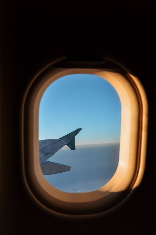 Free Scenic view of airplane wing and sky through window during flight over Ireland. Stock Photo