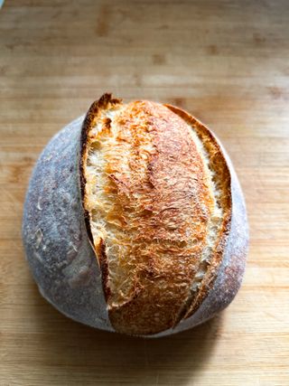 Round sourdough loaf on a wooden board, photo by Evans Joel on Pexels