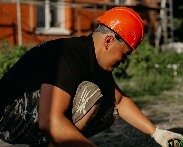 Roofer preparing tools Construction worker in a hard hat working with tools outside a building