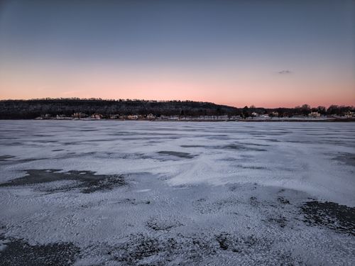 Free A tranquil winter scene of a frozen lake and distant horizon at sunset in Minnesota. Stock Photo