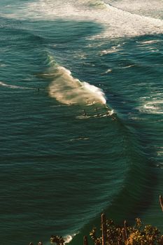 Aerial view of surfers enjoying waves in Arraial do Cabo, Brazil's stunning coastal waters.