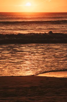 Captivating sunset view over the waves at Arraial do Cabo beach in Brazil, radiating warmth and tranquility.