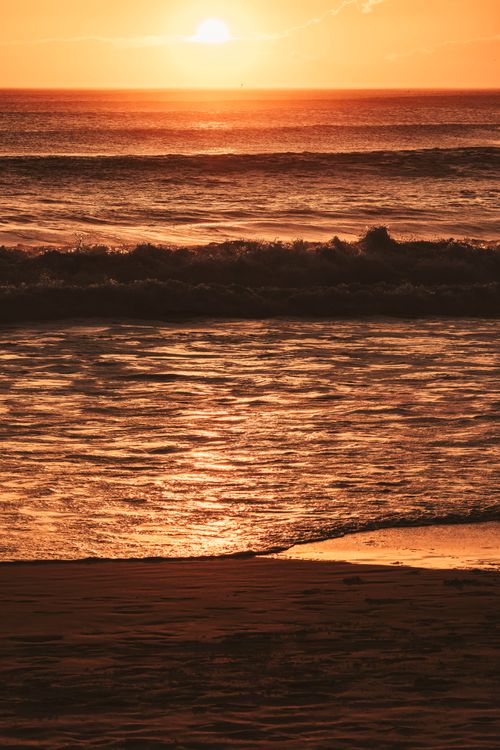 Free Captivating sunset view over the waves at Arraial do Cabo beach in Brazil, radiating warmth and tranquility. Stock Photo