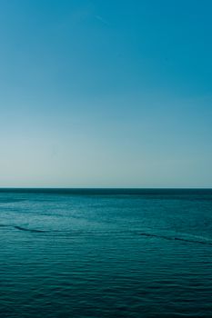 Calm blue waters of the Mediterranean Sea with a clear sky, captured near the Balearic Islands, Spain.