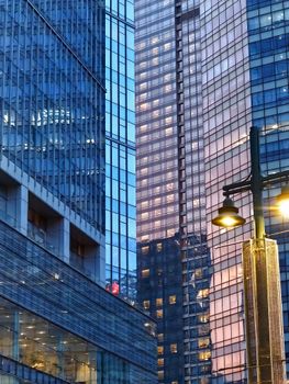 Illuminated skyscrapers and street lamps in Taguig, Metro Manila during twilight, capturing urban architecture.