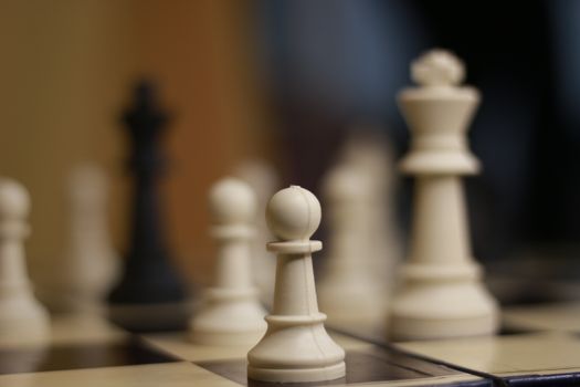 Artistic close-up of chess pieces with focus on a pawn. Captures strategic elegance.