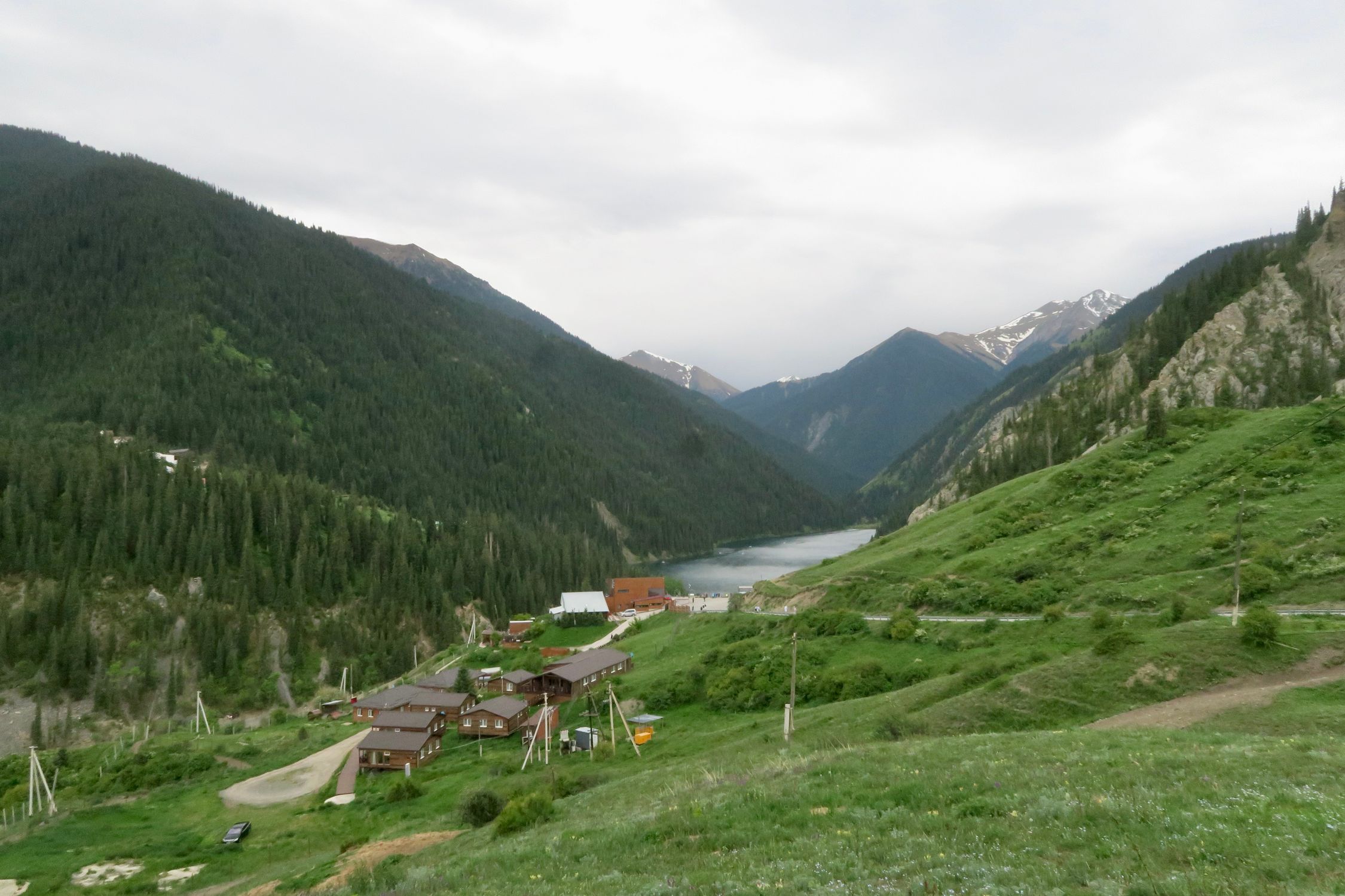 A breathtaking view of the mountains, forest, and lake in Almaty, Kazakhstan, showcasing natural beauty.