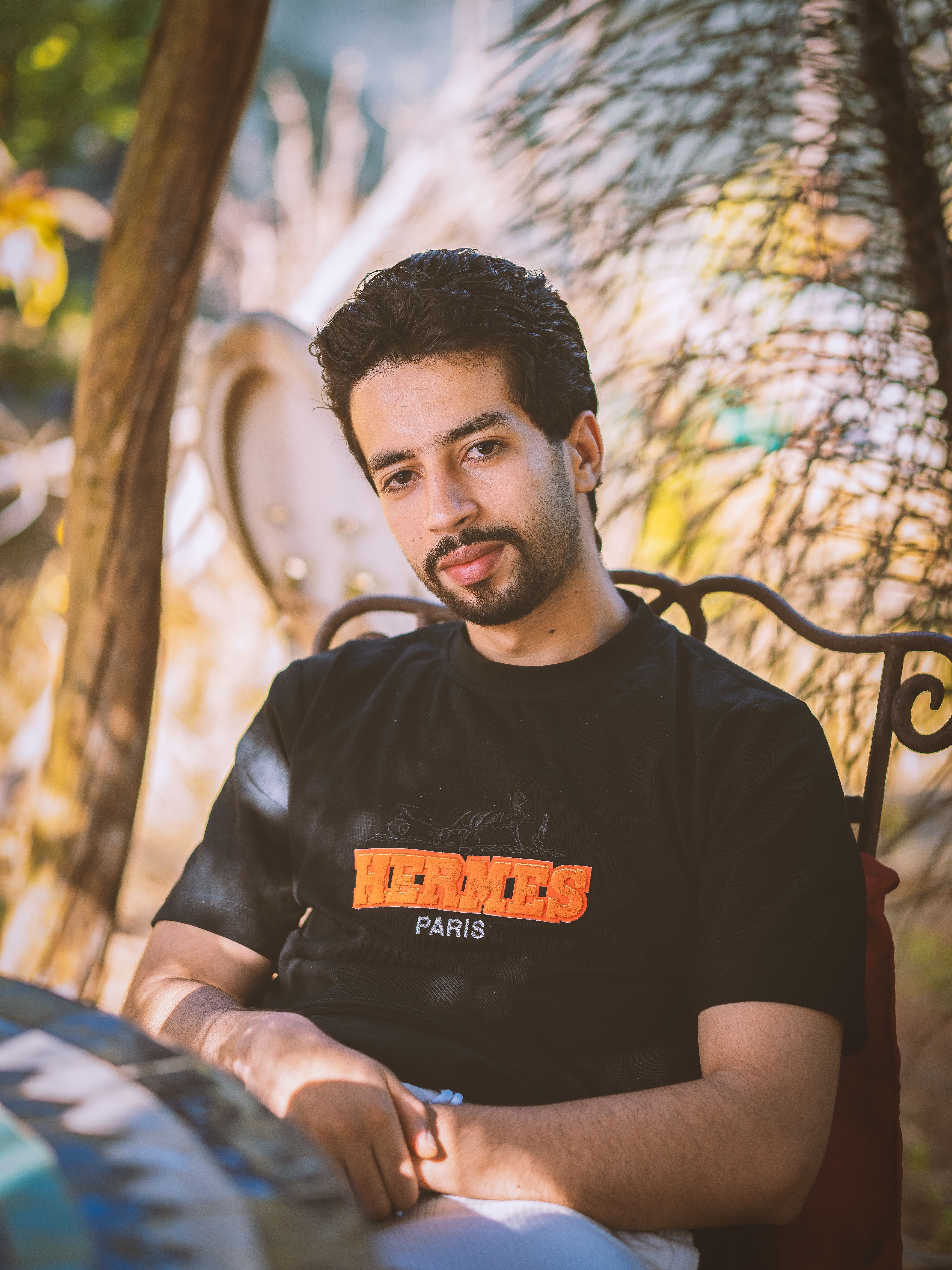 Young man in casual attire relaxing outdoors, enjoying a sunny day.