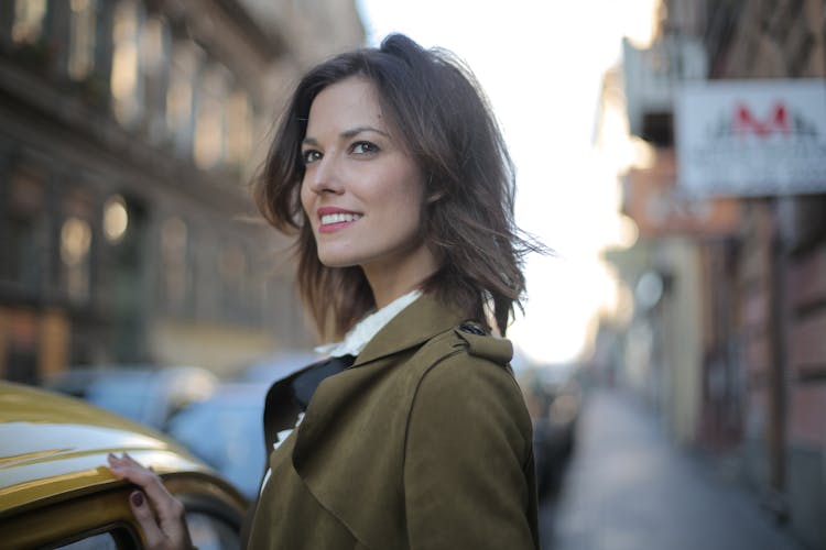 Woman In Green Coat  Standing Near Yellow Cab