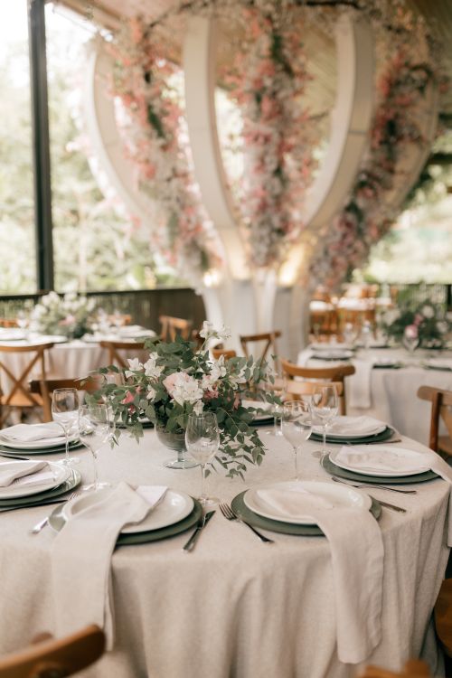 Free Beautifully set tables at a wedding reception adorned with pastel floral arrangements and elegant decor. Stock Photo