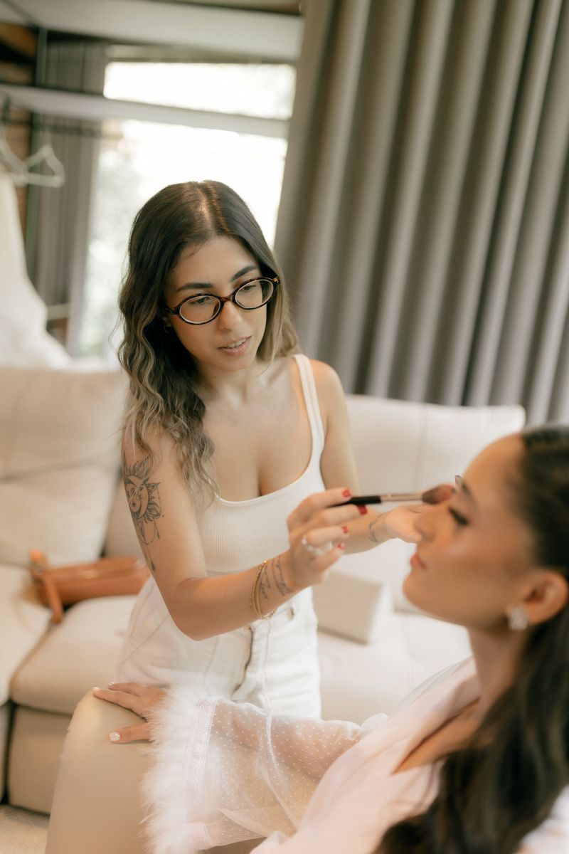 A makeup artist applying a bride's eye makeup