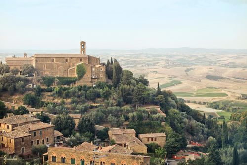 Free From above picturesque view of ancient town with brick buildings and green trees located on hill in sunny day in countryside Stock Photo