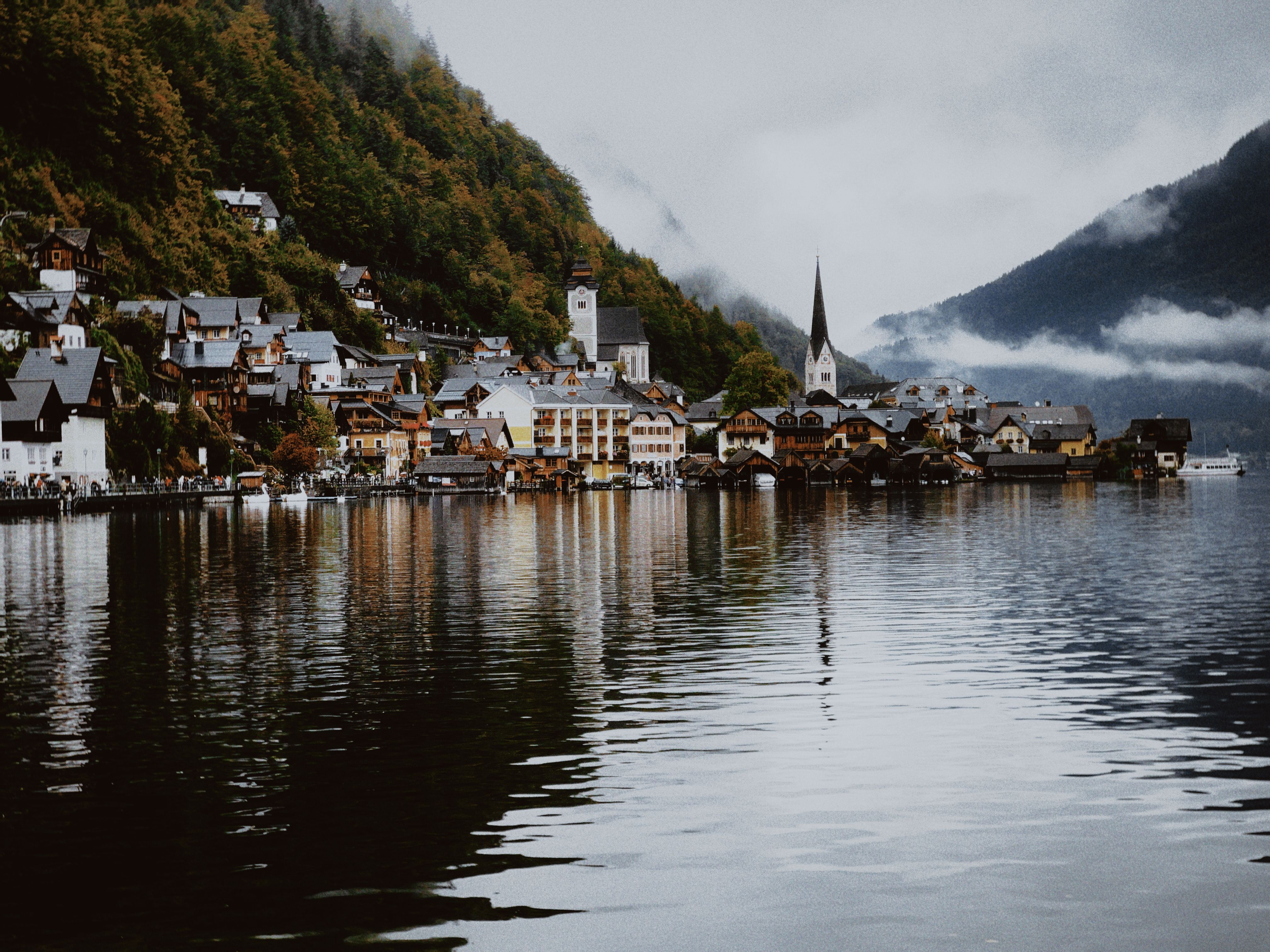 Charming view of Hallstatt village with misty mountains and reflective lake waters.