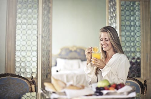Free Cheerful woman enjoying breakfast in morning Stock Photo