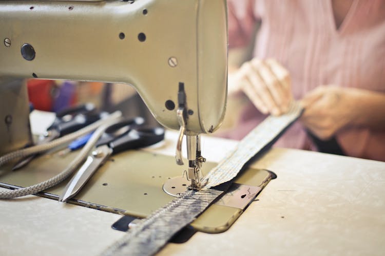 Seamstress Stitching Clothing Item On Sewing Machine