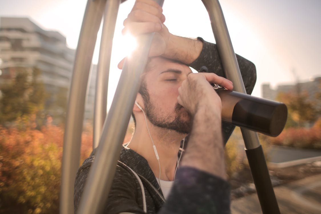 Free Tired sportsman man drinking water during training on street Stock Photo