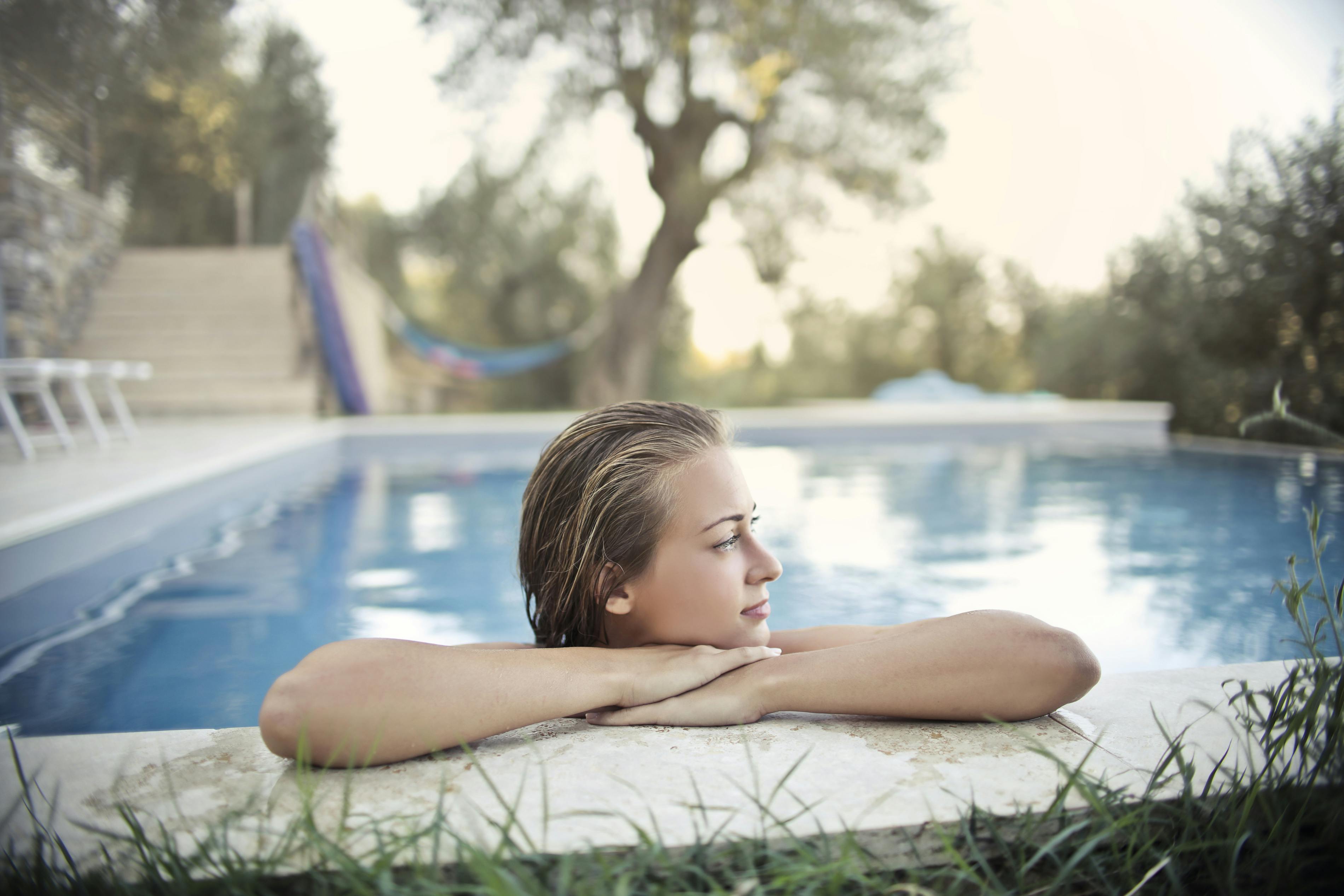 relaxed woman resting at poolside in summer