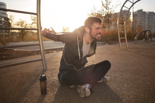 Enthousiaste Homme Athlétique Qui S'étend Des Bras Sur Un Terrain De Sport