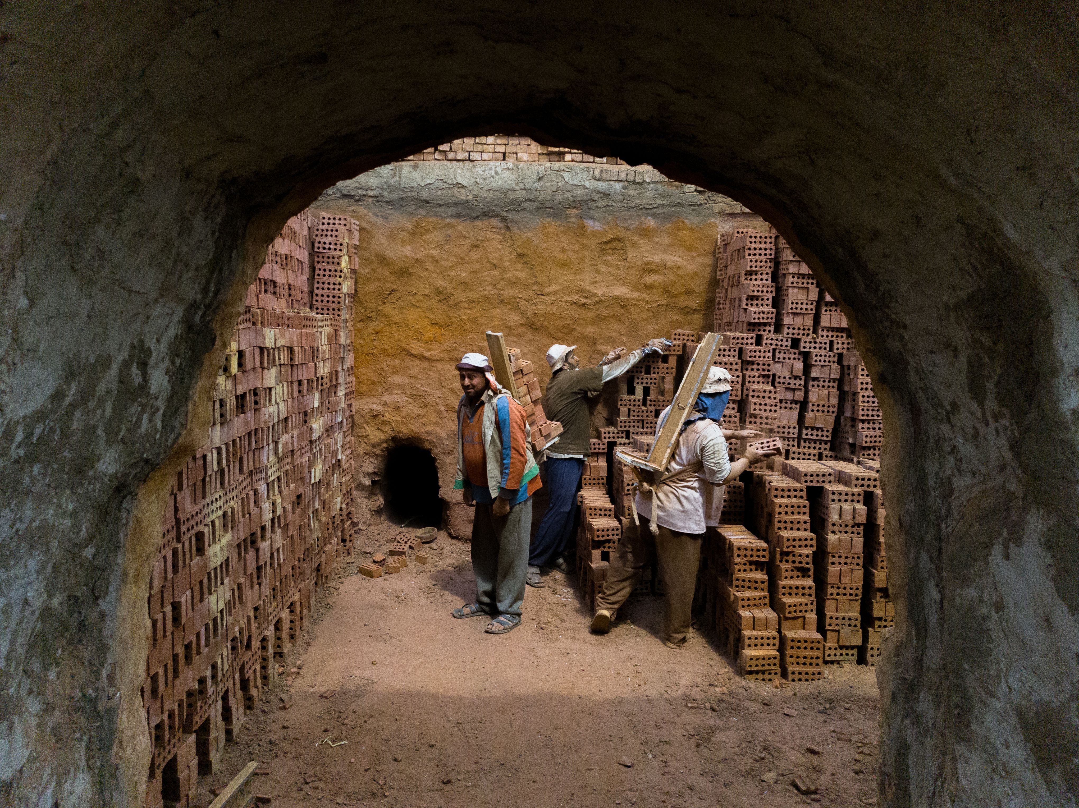 Laborers stacking bricks inside a kiln in Al Qanatir Al Khayriyyah, Egypt.